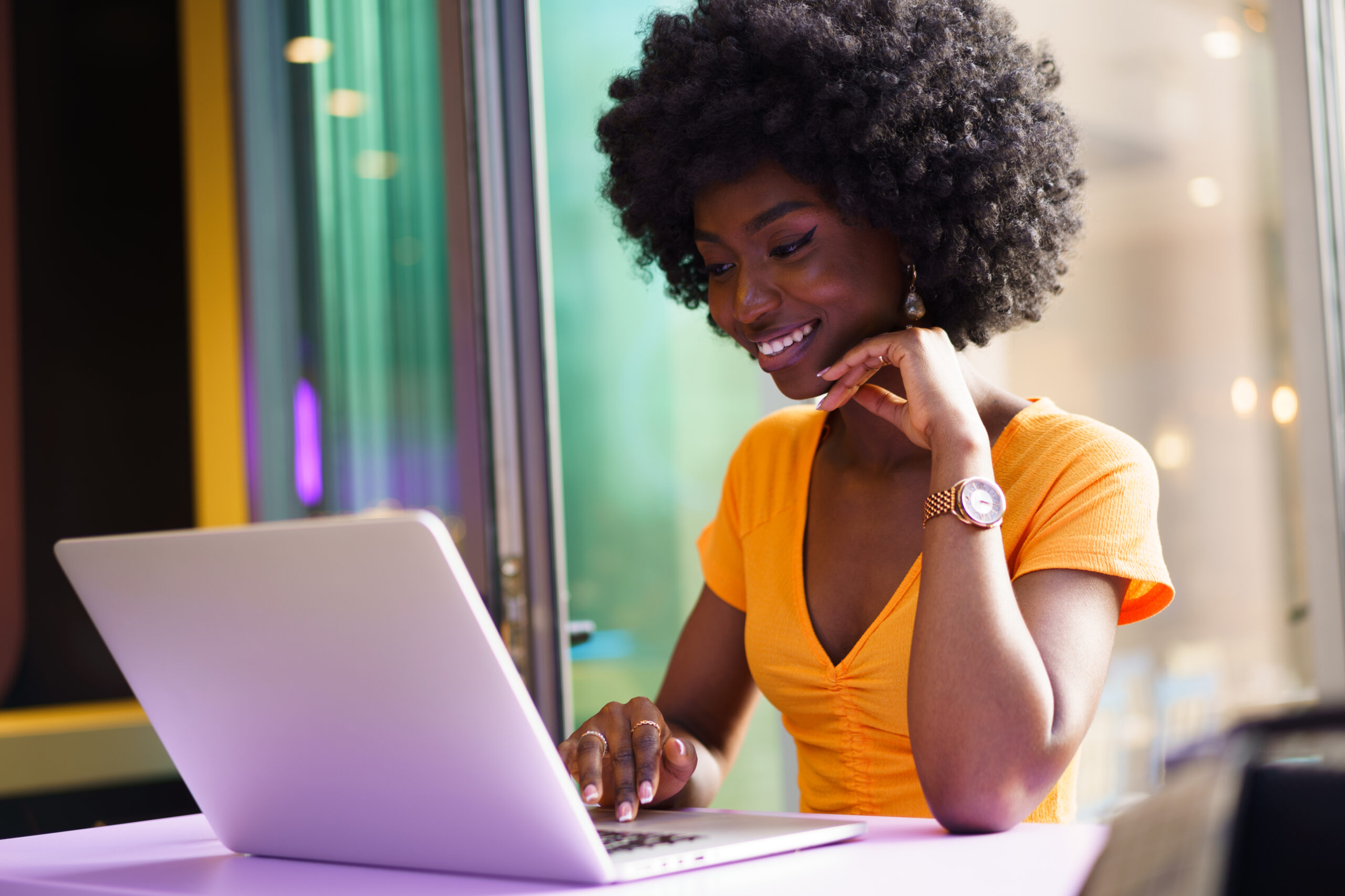 happy beautiful young black woman using laptop