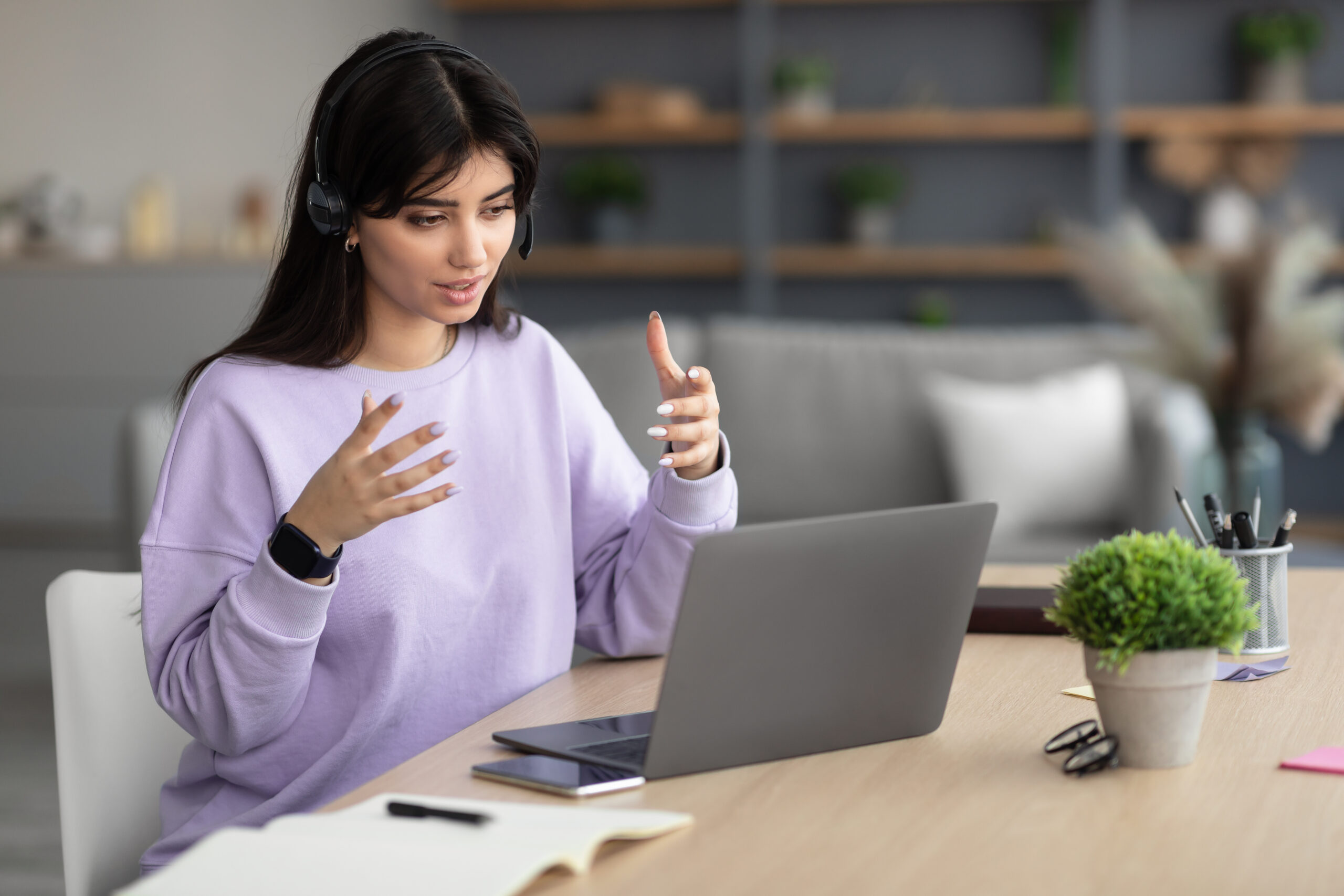 woman in headphones having videocall using laptop