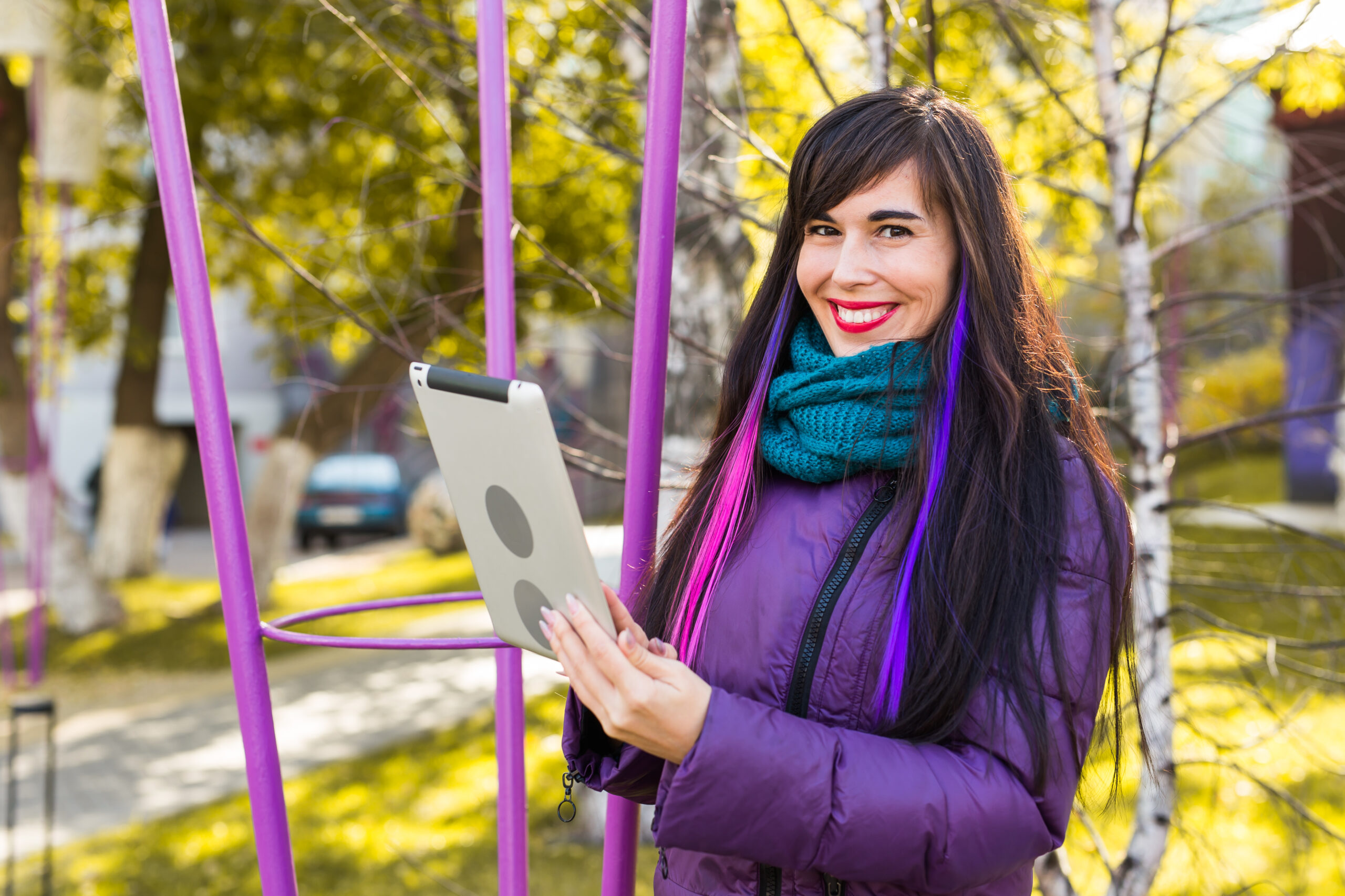 Technologies, urban and people concept - Student young woman reading an ebook or tablet in an urban autumn park.